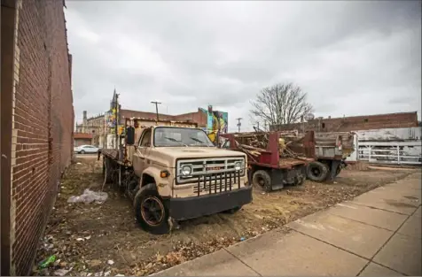  ?? Andrew Rush/Post-Gazette ?? Old Public Works trucks sit in a city-owned lot next to Salik Farouk’s hardware store on North Homewood Avenue. Mr. Farouk says he has been calling his city councilman and state representa­tive about the junk-filled lot for five years.