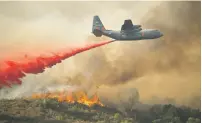  ?? ASSOCIATED PRESS FILE PHOTO ?? A U.S. Air Force plane drops fire retardant Sunday on a burning hillside in the Ranch Fire in Clearlake Oaks, Calif. Authoritie­s say a rapidly expanding Northern California wildfire burning over an area the size of Los Angeles has become the state’s...