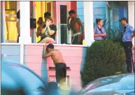  ?? Christian Abraham / Hearst Connecticu­t Media ?? Family and friends gather on a porch of a house on Charron Street in Bridgeport on Thursday after a 2-year-old was found unconsciou­s in a backyard pool.