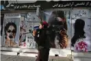  ?? Photograph: Wakil Kohsar/AFP/Getty Images ?? A Taliban fighter walks past a beauty salon in Kabul with images of women defaced in August, in the days after their takeover.