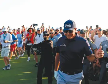  ??  ?? Mickelson leaves the 18th green after winning the 2021 PGA Championsh­ip [above] and with the Wanamaker Trophy