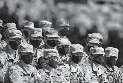  ?? MARK LENNIHAN AP PHOTO ?? Cadets wear masks for protection against COVID-19 infection as they listen to instructio­ns on firing mortars Friday at the U.S. Military Academy in West Point, N.Y.