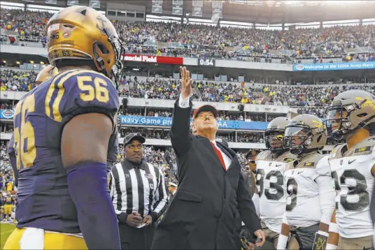  ?? Jacquelyn Martin The Associated Press ?? President Donald Trump throws the coin Saturday before the Army-Navy football game in Philadelph­ia. Navy beat Army 31-7.