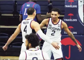  ?? David Butler II / Associated Press ?? UConn guard James Bouknight (2) celebrates with guard Tyrese Martin (4) after making a basket against DePaul during Wednesday’s game.