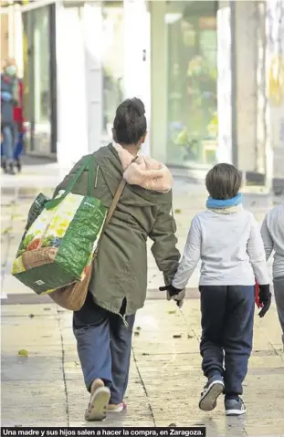  ??  ?? Una madre y sus hijos salen a hacer la compra, en Zaragoza.