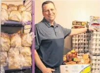  ?? DANIEL BROWN/THE GUARDIAN ?? Mike MacDonald, executive director of Upper Room Hospitalit­y Ministry, showcases a selection of fresh and healthy foods at the Belmont Street food bank in Charlottet­own on Dec. 27.