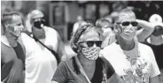  ?? JOHN RAOUX/AP ?? Guests wear masks in the summer sun while visiting the Disney Springs complex June 16 in Lake Buena Vista, Fla.