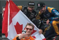  ?? CP PHOTO / CHRIS YOUNG ?? Josef Newgarden, bottom, takes a selfie with third place finisher James Hinchcliff­e, left, and second place finisher Alexander Rossi after winning the Honda Indy Toronto in Toronto on Sunday.