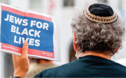  ?? (Valerie Macon/AFP via Getty Images) ?? A KIPPAH-CLAD man holds a sign reading ‘Jews for Black Lives’ at the weekly Black Lives Matter ‘Jackie Lacey Must Go!’ protest in front of the Hall of Justice in Los Angeles last year.