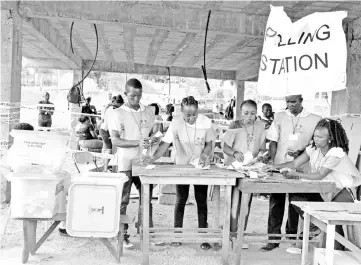  ??  ?? Sierra Leonean election workers check ballot papers as counting takes place at a polling station in Freetown. — AFP photo