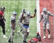  ?? Curtis Compton / Associated Press ?? Lions linebacker Jamie Collins signals touchdown as Falcons running back Todd Gurley tries to stop short of the end zone to control the final minutes of the clock in the fourth quarter last week.