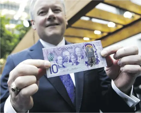  ?? CHRIS ROUSSAKIS / BLOOMBERG ?? Stephen Poloz, governor of the Bank of Canada, holds up a copy of a commemorat­ive $10 note on Friday. The special bank note showcasing Canada’s history, land and culture will enter into circulatio­n on June 1.