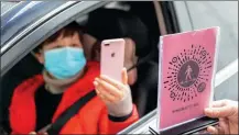  ?? LUO GUOJIA / XINHUA ?? A motorist scans the QR code of a mini program in WeChat before entering a community in Chongqing in February.