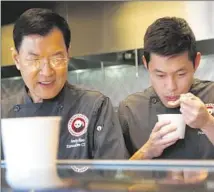  ??  ?? KAO AND LOK taste one of several versions of “lion’s head meatballs.” As the chefs try to Americaniz­e regional Chinese classics, they’re also starting to take bigger chances.