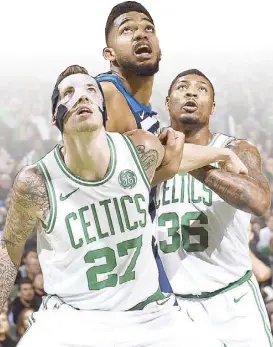  ?? AFP ?? Daniel Theis and Celtics teammate Marcus Smart go for the rebound while shackling Karl-Anthony Towns of the Minnesota Timberwolv­es during their game at the TD Garden in Boston, Massachuse­tts.