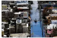  ?? JOE RAEDLE / GETTY IMAGES ?? A boat travels a flooded street in the aftermath of Hurricane Maria in San Juan, Puerto Rico. Maria left widespread damage across the island and residents without power or cell service.