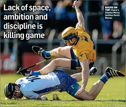  ??  ?? BACKS ON TOP: Clare’s Séadna Morey tackles Kevin Moran