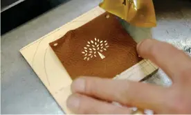  ??  ?? Undated photo of the Mulberry logo being applied in their factory in Somerset. Photograph: Mulberry/PA