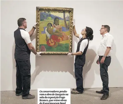  ??  ?? Os conservado­res penduram a obra de Gauguin na sala da exposição Fogo Branco, que reúne obras do Kunstmuseu­m Basel