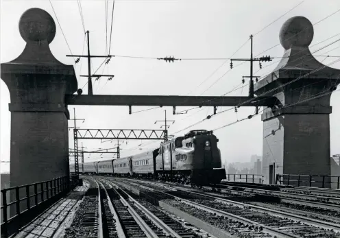  ??  ?? Pairs of pylons mark the ends of the four-span bridge over Little Hell
Gate, a narrow water passage that has since been filled in. GG1 4905 enters the bridge with a train to Boston in November 1972. The two tracks in the foreground are for freight.