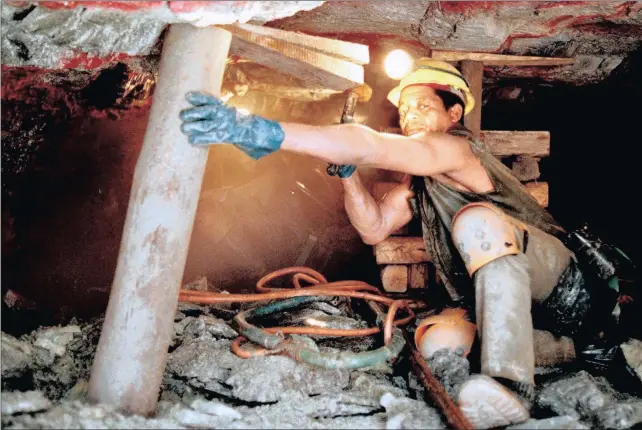  ??  ?? RUMBLES UNDERGROUN­D: A gold miner on the job at ERPM gold mine in Boksburg in this 1997 file photo. The operation of mines reflects society through elitist control, but people are increasing­ly demanding a say in their workplace and their governance,...