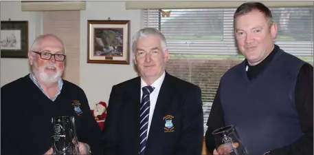  ??  ?? John Lohan and Declan McCann being presented with the winners trophies for the Ballyheigu­e Castle Golf Club Fourball competitio­n from Club Captain Jack Dempsey