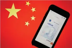  ?? FOTO: FLORENCE LO/LEHTIKUVA-REUTERS ?? Kina går i bräschen för utveckling­en av e-valutor. I oktober genomförde­s det största pilotproje­ktet hittills, då Folkbanken delade ut 200 yuan till 50 000 slumpmässi­gt utvalda kineser.