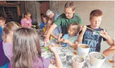  ?? FOTO: HERMANN GEISELMANN ?? Die Kinder werden beim Bemalen ihrer Steine vom OGV-Vorsitzend­en Hans Weber unterstütz­t.