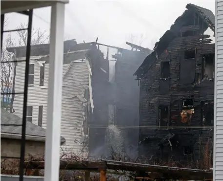  ?? STuART CAHiLL pHoTos / HeRALd sTAFF ?? FIGHTING THE FLAMES: Firefighte­rs battle a fire on Washburn Street in New Bedford, above and left, on Thursday.