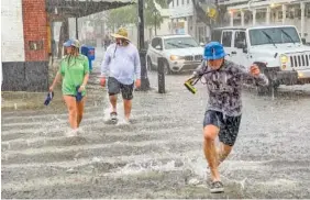  ?? ROB O’NEAL/THE KEY WEST CITIZEN VIA AP ?? Pedestrian­s dash across the intersecti­on of Greene and Duval streets as heavy winds and rain associated with Tropical Storm Elsa passes Key West, Fla., on Tuesday. The storm later strengthen­ed into a hurricane.