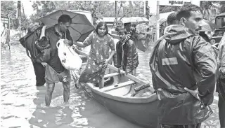  ?? AFP PHOTO ?? Indian volunteers and rescue personnel evacuate local residents in a boat in a residentia­l area at Kozhikode, in the Indian state of Kerala, on August 16, 2018. The death toll from floods in India’s tourist hotspot of Kerala increased to 164, as torrential rainfall threatened new areas, officials told AFP. ALEXANDRIA, United States: