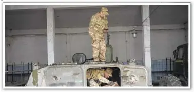  ?? ?? Ukrainian President Volodymyr Zelenskyy hobnobs with soldiers (top) as two of his country’s servicemen inspect a captured Russian military vehicle.