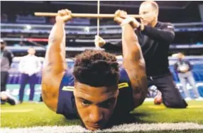  ??  ?? Bucknell offensive lineman Julién Davenport is tested for flexibilit­y at the NFL football scouting combine in Indianapol­is. David J. Phillip, The Associated Press