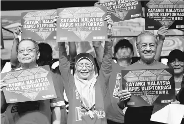  ??  ?? (From right) Dr Mahathir, Datin Seri Wan Azizah and Lim Kit Siang hold placards reading ‘Love Malaysia, End Kleptocrac­y’ during Saturday’s rally in Petaling Jaya. — Reuters photo