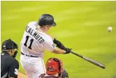  ?? MARK BROWN/GETTY IMAGES ?? Marlins catcher J.T. Realmuto hits against Philadelph­ia right-hander Zach Eflin in the first inning.