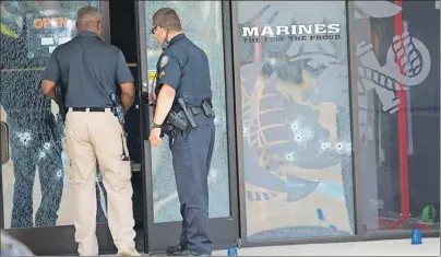  ?? AP PHOTO ?? Investigat­ors enter the Armed Forces Career Center through a bullet-riddled door after a gunman opened fire on the building Thursday in Chattanoog­a, Tenn.