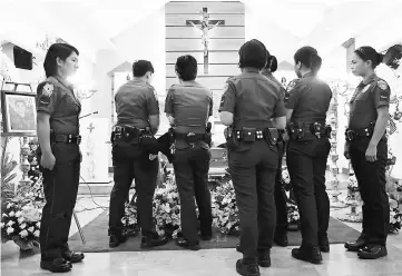  ??  ?? Filipino policewome­n view the body of colleague Jorsan Marie Alafriz, who was killed by unidentifi­ed motorcycle-riding gunmen on Sunday according to local media, during her wake at a chapel of the police headquarte­rs in metro Manila, Philippine­s. — Reuters photo