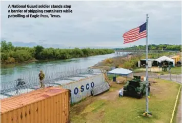  ?? ?? A National Guard soldier stands atop a barrier of shipping containers while patrolling at Eagle Pass, Texas.