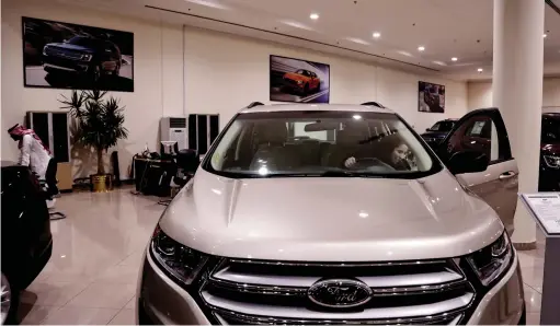  ??  ?? Nour Obeid checks a car at the Al Jazirah Ford showroom in Riyadh, Saudi Arabia. Obeid’s husband is encouragin­g her to get her licence and drive. —