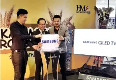  ??  ?? Lui (centre) officiatin­g the launch of Samsung QLED TV witnessed by Lee (right) at Karamunsin­g Complex, Kota Kinabalu yesterday.
