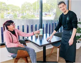  ?? ?? Above: Supported workers Bella McDougal and Paul van doord organise displays with manager Kelly Sheehan and Michael Nix.
Left: Paul van doord serves customer Jenny Gavin a takeaway coffee.