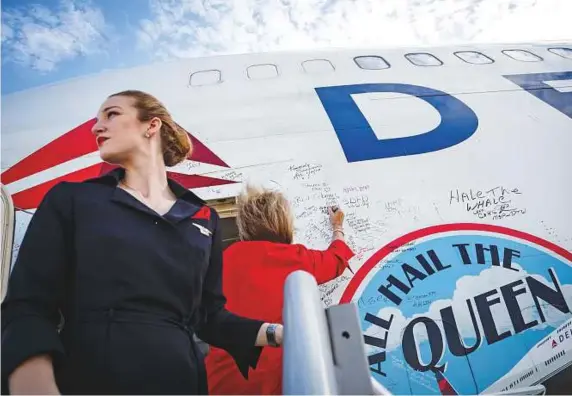  ?? New York Times ?? Crew members who staffed Delta Air Lines’ final Boeing 747 flights autograph the plane with markers at Pinal Airpark in Marana, Arizona on January 4. The final 747 flight by any commercial United States airline took to the skies with some tears and...