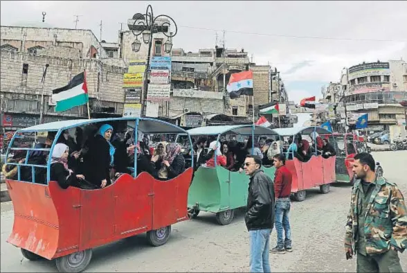  ?? JOSEPH EID / AFP ?? Banderas sirias y palestinas en un transporte público artesanal en la ciudad de Hama, el pasado lunes