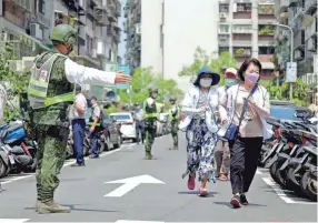 ?? CHIANG YING-YING/AP ?? Taiwanese soldiers direct people to a shelter during an air raid drill in Taipei Monday as the military began several days of exercises.