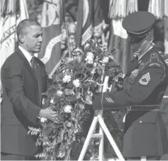  ?? MARK WILSON, GETTY IMAGES ?? President Obama positions a wreath during a ceremony on Veterans Day at the Tomb of the Unknowns at Arlington National Cemetery.