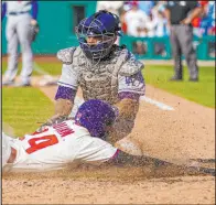  ?? Chris Szagola The Associated Press ?? Roman Quinn scores the winning run past Dodgers catcher Austin Barnes in the 10th inning of the Phillies’ 4-3 victory Sunday.