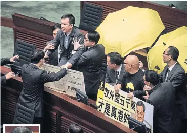  ?? AFP ?? Pro-democracy lawmakers Raymond Chan (top left) and Albert Chan (third right) are taken away after they interrupte­d the policy address of Hong Kong Chief Executive Leung Chun-ying, as others hold yellow umbrellas, a symbol of their movement.