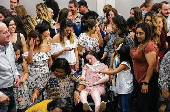  ?? Mark Mulligan / Houston Chronicle ?? Friends and family surround Mandy Coleman after a group photo during a party celebratin­g her 32nd birthday in September. Mandy suffered brain trauma in a car accident in 2014. As in Nick Tullier’s case, Mandy’s family was told she wouldn’t recover. Though she’s suffered setbacks after therapy, she’s likely still conscious.