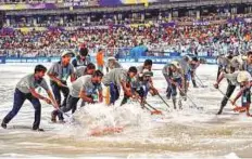  ?? PTI ?? Groundsmen remove water from the ground after rain interrupte­d the match between KKR and KXIP.