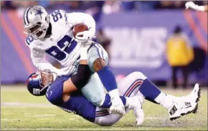  ?? ELSA/GETTY IMAGES/AFP ?? Cedric Thornton of the Dallas Cowboys is tackled by Weston Richburg of the New York Giants in their game at MetLife Stadium on Sunday.